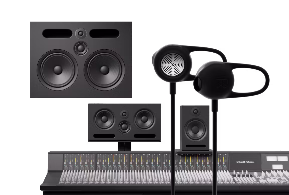 Black binaural in-ear measurement microphone positioned in front of professional studio monitors and mixing console, representing SoundID Reference Virtual Monitoring PRO concept.
